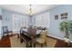 Elegant dining room featuring a large wooden table, shuttered windows, and contemporary chandelier at 15702 Muirfield Dr, Odessa, FL 33556