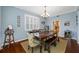 Charming dining room featuring a chandelier, plantation shutters, and hardwood floors at 15702 Muirfield Dr, Odessa, FL 33556
