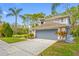 Two-story home with a two-car garage, blue paint, and landscaping at 15702 Muirfield Dr, Odessa, FL 33556