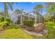 Exterior view of a blue two story home with large screened-in pool enclosure and green lawn at 15702 Muirfield Dr, Odessa, FL 33556