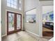 Elegant foyer with stained glass double doors, high ceilings, and views into dining and living areas at 15702 Muirfield Dr, Odessa, FL 33556