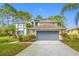 Charming two-story home featuring a large garage, well-kept lawn and mature landscaping at 15702 Muirfield Dr, Odessa, FL 33556
