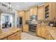 Stylish kitchen featuring stainless steel appliances, custom cabinetry, and tile backsplash at 15702 Muirfield Dr, Odessa, FL 33556