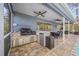 Outdoor kitchen with built-in grill and bar area by the screened pool at 15702 Muirfield Dr, Odessa, FL 33556