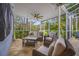 Covered outdoor patio with wicker seating, a ceiling fan, and views of the lush green backyard at 15702 Muirfield Dr, Odessa, FL 33556