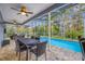 Outdoor covered patio featuring a dining table, views of the pool, and backyard landscaping at 15702 Muirfield Dr, Odessa, FL 33556