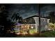 Well lit home exterior with screened-in lanai and pool at night at 15702 Muirfield Dr, Odessa, FL 33556