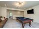 Large game room features a pool table, comfortable couch, and stylish lighting fixtures at 16349 Hyde Manor Dr, Tampa, FL 33647