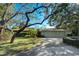 Charming home with a three car garage, mature landscaping, and large shade trees on a well maintained lawn at 1672 Winding Creek Rd, Dunedin, FL 34698