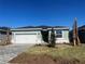 Charming single-story home featuring a paver driveway, two-car garage, and manicured lawn at 17049 James Trl, Parrish, FL 34219