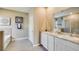 Bright bathroom featuring double vanity, granite counters, framed mirrors, soaking tub, and tile flooring at 17053 James Trl, Parrish, FL 34219
