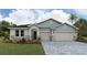 Charming exterior view of a two-story home with a stone-accented facade and well-manicured lawn at 17114 James Trl, Parrish, FL 34219