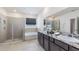 Well-lit bathroom with double vanity, granite countertops, soaking tub, and glass-enclosed shower at 17126 James Trl, Parrish, FL 34219