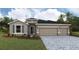 Charming one-story home with three-car garage, stone accents, and manicured landscaping at 17126 James Trl, Parrish, FL 34219