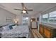 Cozy bedroom with wood floor, neutral paint, ceiling fan, and large windows for lots of natural light at 1805 Columbine Pl, Sun City Center, FL 33573