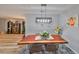 Charming dining area features a natural wood table, modern lighting, and decor at 1805 Columbine Pl, Sun City Center, FL 33573