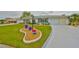 Well-manicured lawn features unique planters in front of this bright home with attached garage and mature landscaping at 1805 Columbine Pl, Sun City Center, FL 33573