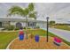Beautiful landscaping complements this well-maintained house with an attached garage and a dark-colored front door at 1805 Columbine Pl, Sun City Center, FL 33573