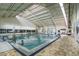 Well-lit indoor swimming pool featuring a spacious area, ample seating, and many swimmers at 1805 Columbine Pl, Sun City Center, FL 33573