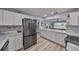 Bright kitchen featuring stainless steel appliances, white cabinets, and marble countertops at 1805 Columbine Pl, Sun City Center, FL 33573