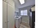 Functional laundry room with white washer and dryer, storage cabinets, and natural light at 1805 Columbine Pl, Sun City Center, FL 33573