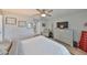 Well-lit main bedroom displays wood flooring, a ceiling fan, and connects to the main bath with a large dresser at 1805 Columbine Pl, Sun City Center, FL 33573