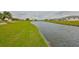 Picturesque view of canal front property with mature trees and green grass at 1805 Columbine Pl, Sun City Center, FL 33573