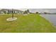 Expansive lawn leading to waterfront, complemented by lush landscaping and community views at 1805 Columbine Pl, Sun City Center, FL 33573