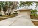 Charming single-story home featuring a manicured front yard, mature tree, and a two-car garage at 18186 Sandy Pointe Dr, Tampa, FL 33647