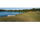 View of the beautiful golf course and pond with a boat ashore, a green space for various activities at 18186 Sandy Pointe Dr, Tampa, FL 33647