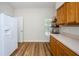 A bright kitchen area with a refrigerator, shelving, and wood-style laminate flooring at 18186 Sandy Pointe Dr, Tampa, FL 33647