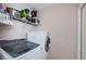 Bright laundry room features a modern washer and dryer with storage shelves at 18186 Sandy Pointe Dr, Tampa, FL 33647