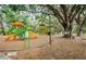 Colorful playground with slides and climbing structures nestled among mature trees and wood chip ground cover at 18186 Sandy Pointe Dr, Tampa, FL 33647