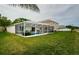 Private screened-in pool and patio area in a backyard with green grass at 18186 Sandy Pointe Dr, Tampa, FL 33647