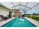The gorgeous, screened-in outdoor pool has nearby chairs, a table, and a grill at 18186 Sandy Pointe Dr, Tampa, FL 33647