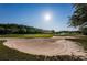 View of the well-maintained golf course with large sand trap and beautiful green landscape at 18186 Sandy Pointe Dr, Tampa, FL 33647