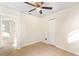 Comfortable bedroom with neutral tile floors, ceiling fan, closet and access to the hallway at 184 Garden Nw Ave, Port Charlotte, FL 33952