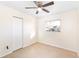 Bright bedroom with tile flooring, ceiling fan, and a window overlooking the yard at 184 Garden Nw Ave, Port Charlotte, FL 33952