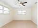 Bright bedroom offers neutral walls, tiled floors, ceiling fan, and two windows for natural light at 184 Garden Nw Ave, Port Charlotte, FL 33952