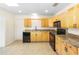 Charming kitchen featuring wooden cabinets, granite countertops and black appliances at 184 Garden Nw Ave, Port Charlotte, FL 33952