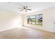 Cozy living room with a ceiling fan and a large window offering a view of the neighborhood at 184 Garden Nw Ave, Port Charlotte, FL 33952