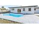Backyard featuring a kidney-shaped pool with a concrete patio, windows, and a sliding glass door at 184 Garden Nw Ave, Port Charlotte, FL 33952