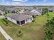 Rear exterior view showing large grassy yard, mature trees, and a screened in patio at 19477 Coastal Shore Ter, Land O Lakes, FL 34638