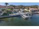 Stunning waterfront home featuring a private dock, boat lift, swimming pool, and lush tropical landscaping at 1984 Kansas Ne Ave, St Petersburg, FL 33703