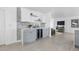 Modern bar area with wine fridge, custom backsplash, floating shelves, and adjacent living space at 1984 Kansas Ne Ave, St Petersburg, FL 33703