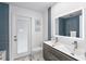 Bathroom featuring double sink vanity, blue tile accent, and a backlit mirror at 1984 Kansas Ne Ave, St Petersburg, FL 33703
