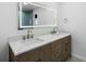 Bathroom featuring double sink vanity, granite counters and a large, backlit mirror at 1984 Kansas Ne Ave, St Petersburg, FL 33703