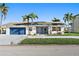 Beautiful one-story home with blue garage door, impact windows, and well-manicured lawn and landscaping at 1984 Kansas Ne Ave, St Petersburg, FL 33703