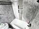 This bathroom offers a built-in shower caddy, a large tub and modern gray tile at 1988 Georgia S Cir, Clearwater, FL 33760