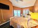Light bedroom featuring dark flooring, an mounted TV, and ample natural light at 1988 Georgia S Cir, Clearwater, FL 33760